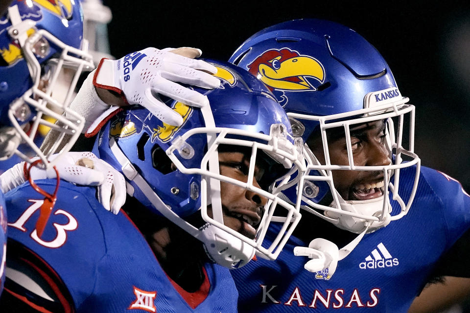 Kansas linebacker Eriq Gilyard (13) celebrates with cornerback Shaad Dabney, right, after intercepting a pass during the second half of an NCAA college football game Friday, Sept. 2, 2022, in Lawrence, Kan. Kansas won 56-10. (AP Photo/Charlie Riedel)