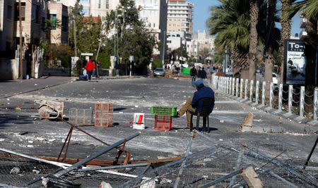 A Palestinian man sits on a chair in a street following clashes with Israeli forces near Ramallah, in the Israeli-occupied West Bank December 15, 2018. REUTERS/Mohamad Torokman