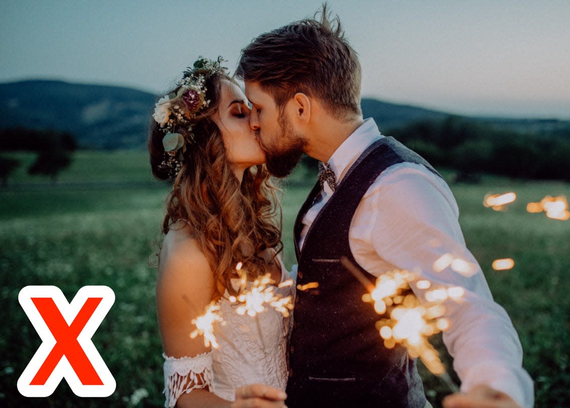 a bride and. groom holding sparklers with an "X" drawn in the corner