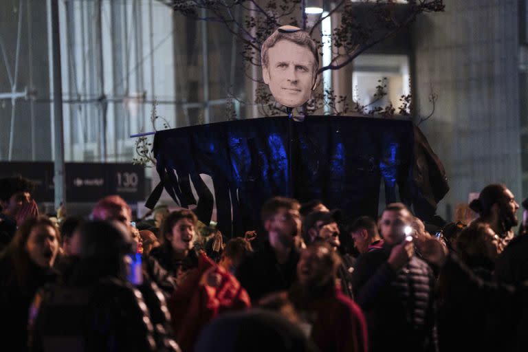 Manifestantes con un retrato del presidente francés Emmanuel Macron, en París el 18 de marzo de 2023. (Foto AP /Lewis Joly)