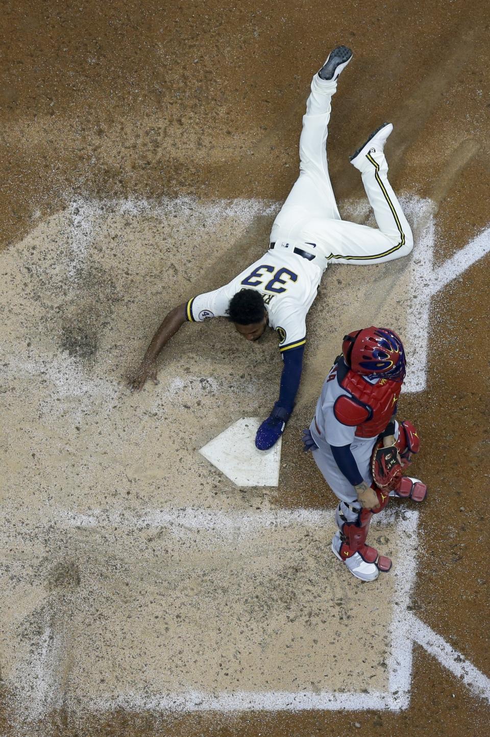 Milwaukee Brewers' Pablo Reyes scores past St. Louis Cardinals catcher Yadier Molina during the eighth inning of a baseball game Wednesday, May 12, 2021, in Milwaukee. Reyes scored from first on a double by Travis Shaw. (AP Photo/Morry Gash)