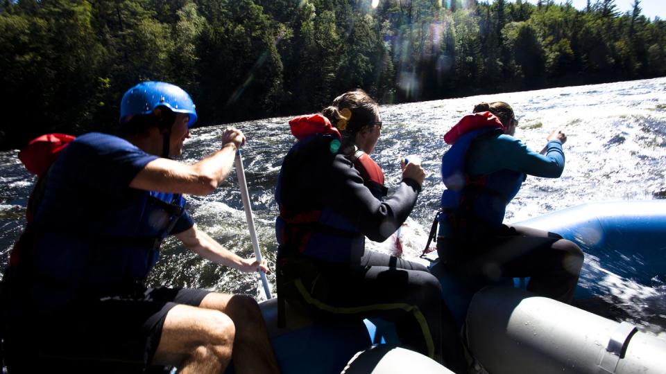 a group of adults whitewater rafting in maine