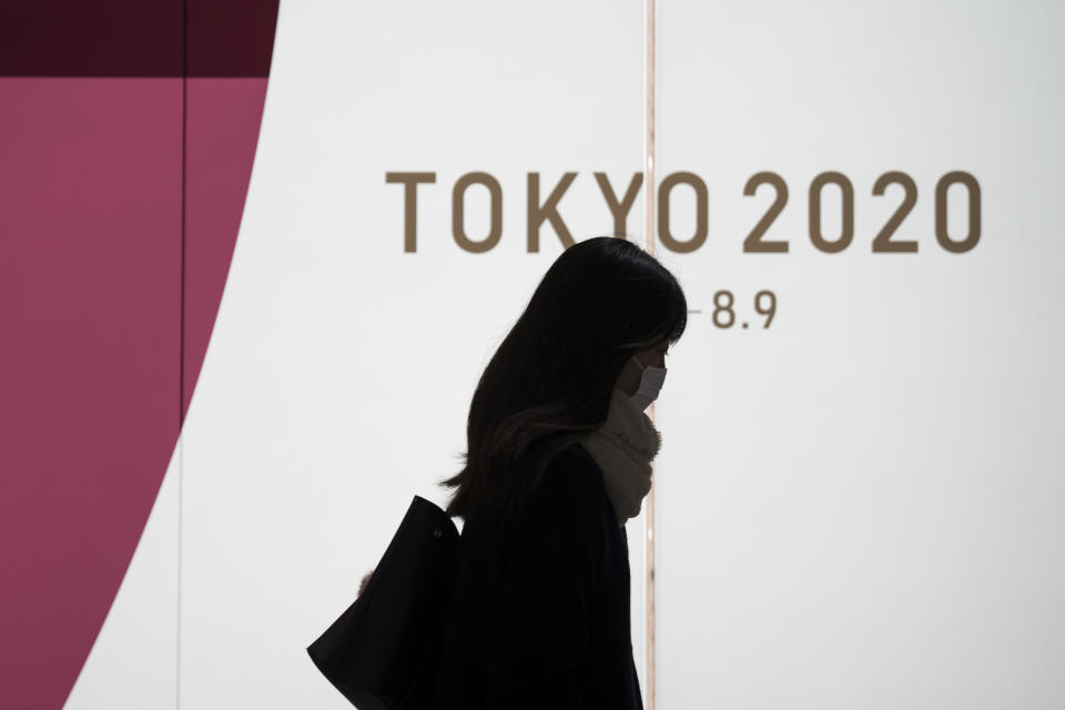 TOKYO, JAPAN - FEBRUARY 26: A pedestrian wearing a face mask walks past a display promoting the upcoming Tokyo 2020 Olympic and Paralympic Games on February 26, 2020 in Tokyo, Japan. Concerns that the Tokyo Olympics may be postponed or cancelled are increasing as Japan confirms 862 cases of Coronavirus (COVID-19) and as some professional sporting contests are being called off or rescheduled and some major Japanese corporations ask for people to work from home. (Photo by Tomohiro Ohsumi/Getty Images)