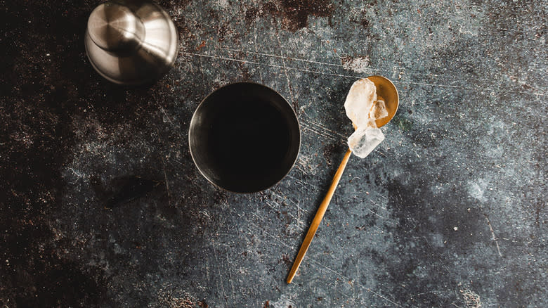 Shaker with ingredients in it and ice on spoon