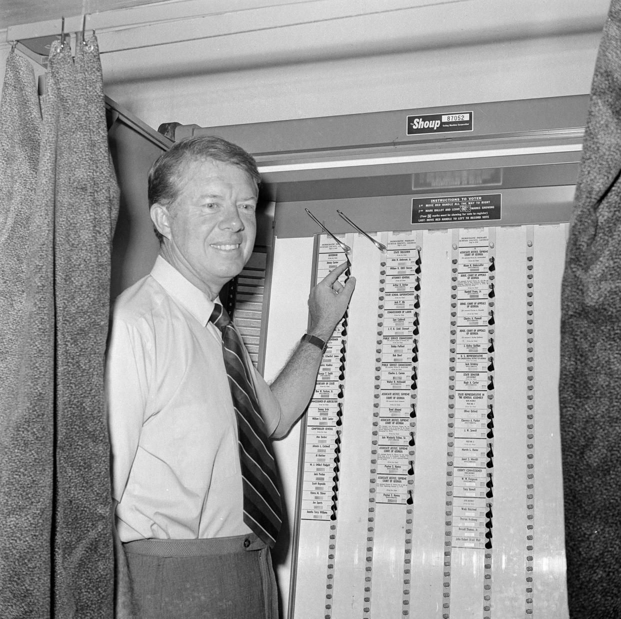 Jimmy Carter, the Democratic gubernatorial candidate, points to his name in a voting machine as he casts his primary vote on Sept. 9, 1970, in his hometown of Plains, Ga.