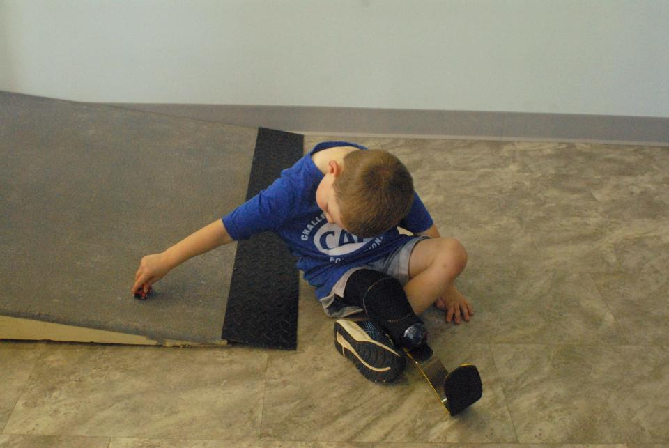 TJ DeAngelo, 3, plays with toy cars during a visit to Next Step Bionics in Manchester, New Hampshire, where he is fitted for his prostheses.