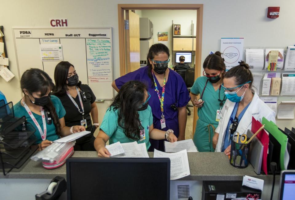 Medical clinic workers huddle at a counter
