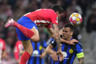 Atletico Madrid's Stefan Savic, left, fights for the ball with Inter Milan's Lautaro Martinez during the Champions League, round of 16, second leg soccer match between Atletico Madrid and Inter Milan at the Metropolitano stadium in Madrid, Spain, Wednesday, March 13, 2024. (AP Photo/Manu Fernandez)