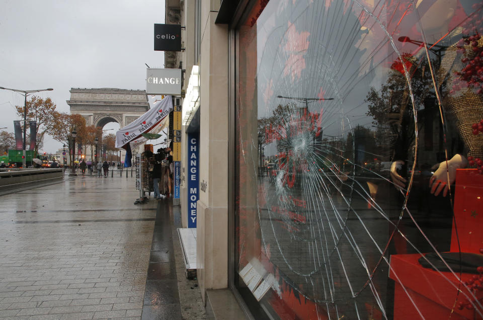 A smashed window of a shop is pictured at the Champs Elysees avenue in Paris, France, Sunday, Nov 25, 2018 in the aftermath of a protest against the rising of the fuel taxes. French President Emmanuel Macron has condemned violence by protesters at demonstrations against rising fuel taxes and his government. (AP Photo/Michel Euler)