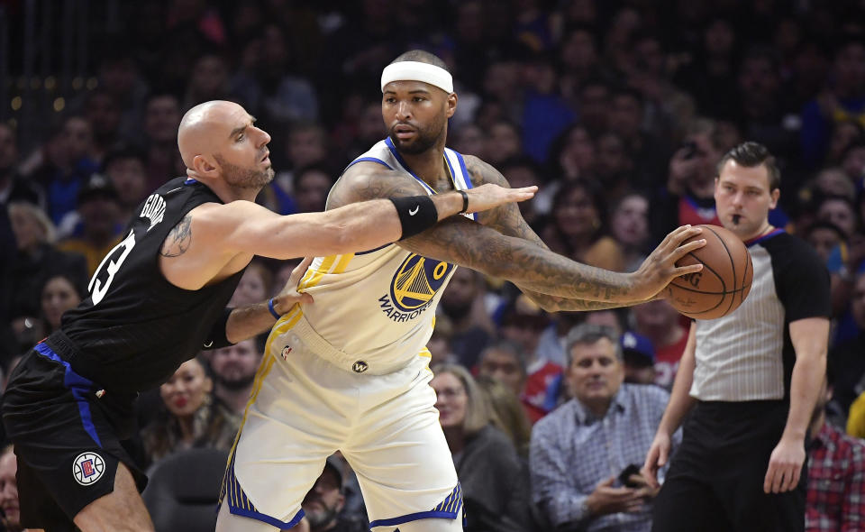 Los Angeles Clippers center Marcin Gortat, left, reaches in on Golden State Warriors center DeMarcus Cousins during the first half of an NBA basketball game Friday, Jan. 18, 2019, in Los Angeles. (AP Photo/Mark J. Terrill)