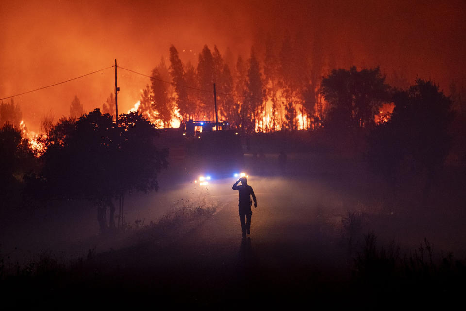 Members of the emergency services try to extinguish a wildfire near Cardigos village, in central Portugal on Sunday, July 21, 2019. About 1,800 firefighters were struggling to contain wildfires in central Portugal that have already injured people, including several firefighters, authorities said Sunday. (AP Photo/Sergio Azenha)