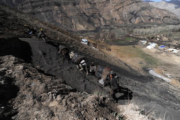 An Afghan miner walks up a slope outside a coal mine in Samangan Province, north of Kabul, on April 3, 2012. (Photo: QAIS USYAN/AFP via Getty Images)