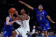 Michigan State's A.J. Hoggard (11) drives past Kansas' Dajuan Harris (3) during the first half of an NCAA basketball game Tuesday, Nov. 9, 2021, in New York. (AP Photo/Frank Franklin II)