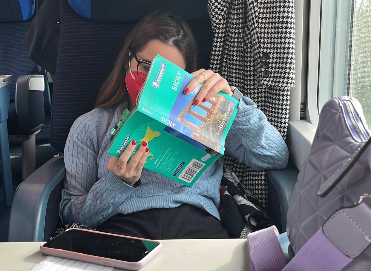 Woman reading an italian guidebook on a train