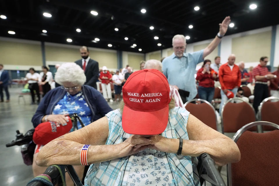 Supporters pray during the invocation before Republican presidential candidate former President Donald Trump speaks at his birthday celebration, hosted by Club 47, in West Palm Beach, Fla., Friday, June 14, 2024. (AP Photo/Gerald Herbert)