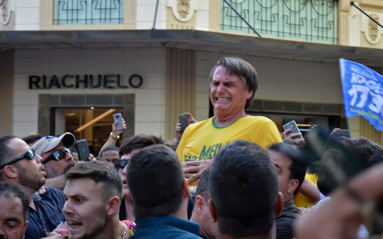 Jair Bolsonaro gestures after being stabbed in the stomach during a campaign rally in Juiz de Fora - AFP