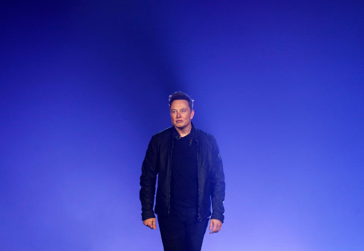 Billionaire Elon Musk is pictured walking during a presentation.