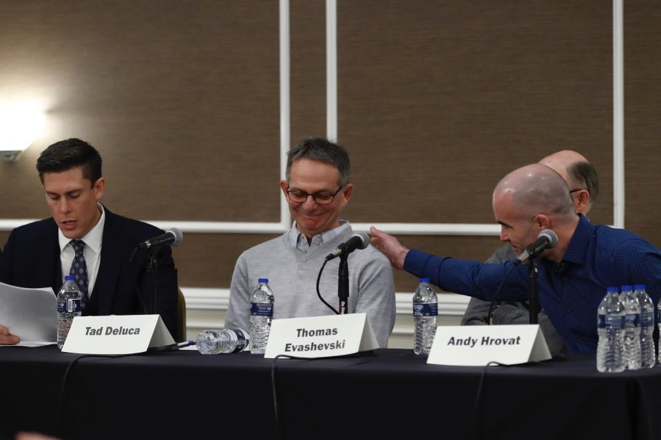 Tad Deluca, center, listens as attorney Parker Stinar addresses the media during a news conference, Thursday, Feb. 27, 2020 in Southfield, Mich. Deluca, a University of Michigan wrestler from the 1970s says he was kicked off the team and lost his financial aid after complaining to a coach that he had been abused by a sports doctor. Deluca identified himself as the whistleblower whose 2018 complaint about the late Dr. Robert E. Anderson led to a police investigation. (AP Photo/Carlos Osorio)