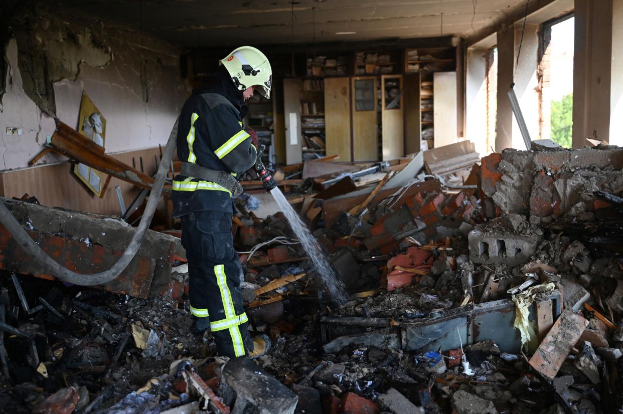 A firefighter secures a partially destroyed educational and laboratory building of a college hit the day before by a rocket in Kharkiv on June 21, 2022. 