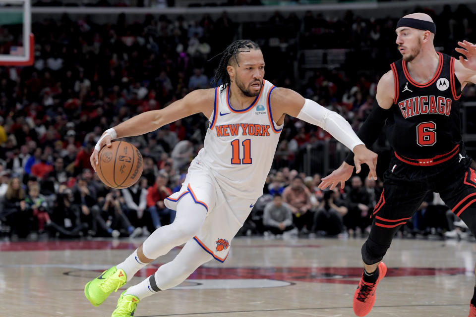 New York Knicks Jalen Brunson (11) drives around Chicago Bulls Alex Caruso (6) during the second quarter of an NBA basketball game in Chicago, Friday, April 5, 2024. (AP Photo/Mark Black)