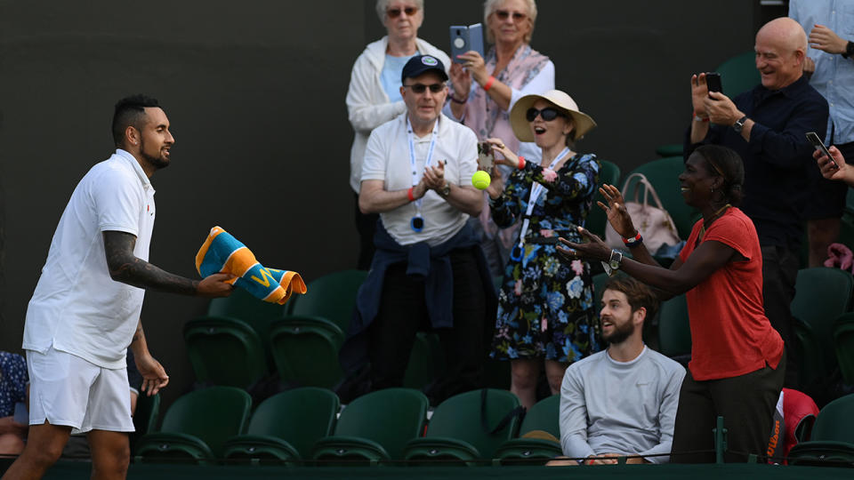 Nick Kyrgios gives a fan who gave him some helpful advice his towel and a ball.