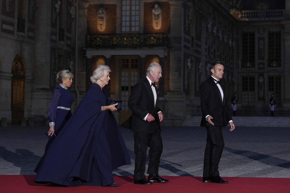 French President Emmanuel Macron, right, his wife Brigitte Macron, left, Britain's King Charles III, second from right, and Queen Camilla arrive for a state dinner, at the Chateau de Versailles, west of Paris, Wednesday, Sept. 20, 2023. King Charles III of the United Kingdom starts a three-day state visit to France on Wednesday meant to highlight the friendship between the two nations with great pomp, after the trip was postponed in March amid widespread demonstrations against President Emmanuel Macron's pension changes. (AP Photo/Christophe Ena)