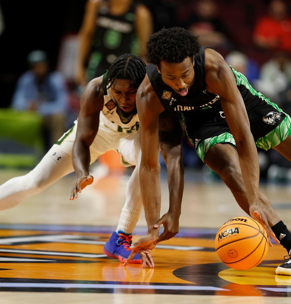 Players from Utah Valley University and UAB scramble for a loose ball during an NIT semifinal game on March 28, 2023.
