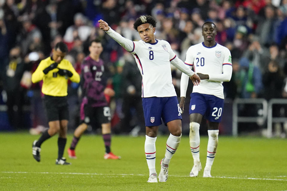 United States' Weston McKennie (8) reacts after scoring a goal as teammate Tim Weah (20) looks on during the second half of a FIFA World Cup qualifying soccer match against Mexico, Friday, Nov. 12, 2021, in Cincinnati. The U.S. won 2-0. (AP Photo/Julio Cortez)