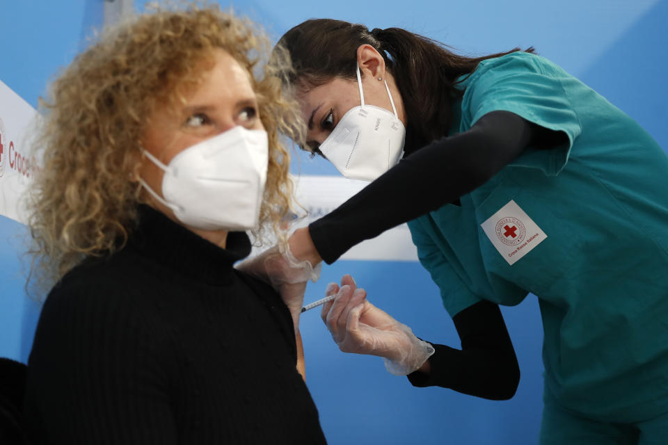 FILE - In this Feb. 11, 2021 file photo a health worker administers a dose of the AstraZeneca vaccine to a woman at a vaccination center set up in Fiumicino, near Rome's international airport. As Poland began vaccinating teachers on Friday Feb. 12, 2021 many say they are unhappy that they are getting AstraZeneca vaccines against the coronavirus, rather than the Pfizer shots earmarked for health care workers and the elderly. Nearly a year into the pandemic, many Europeans and others globally are desperate to get vaccinated and return to normal life. But many don't want just any vaccine. (AP Photo/Alessandra Tarantino, File)