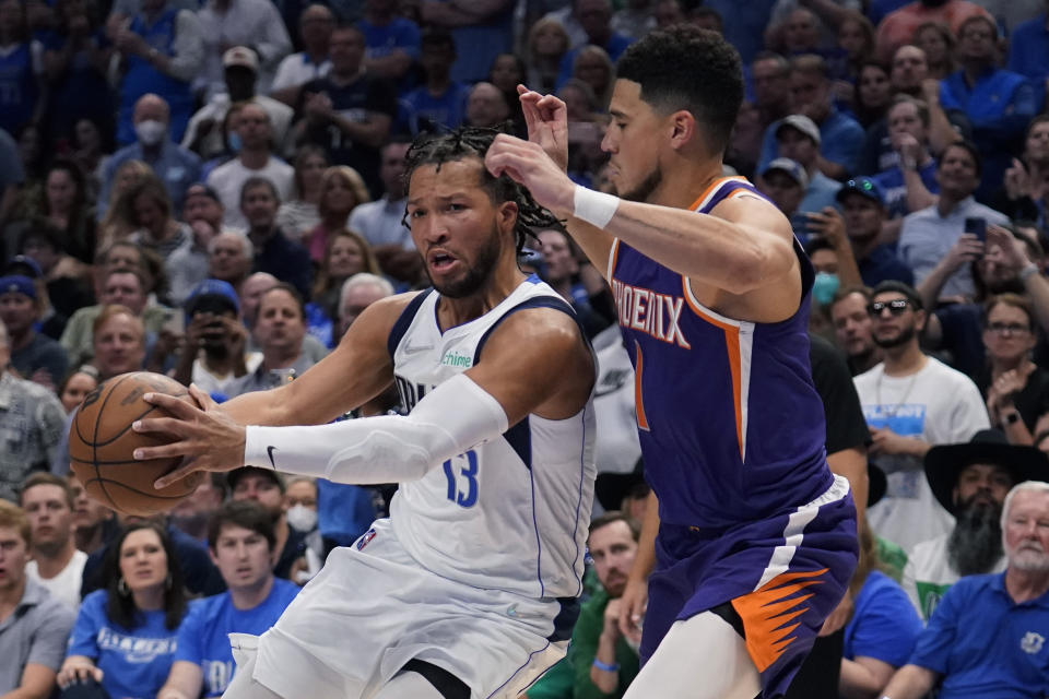 Dallas Mavericks guard Jalen Brunson (13) drives around Phoenix Suns guard Devin Booker (1) during the second half of Game 3 of an NBA basketball second-round playoff series, Friday, May 6, 2022, in Dallas. (AP Photo/Tony Gutierrez)