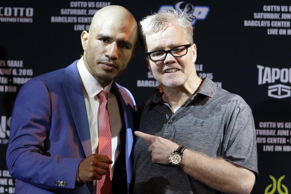 Boxer Miguel Cotto, left, poses for photographers with his trainer Freddie Roach during a news conference, Tuesday, June 2, 2015, in New York. Cotto is slated to defend his WBC world middleweight title against Daniel Geale on Saturday, June 6, at Barclays Center in the Brooklyn borough of New York. (AP Photo/Mary Altaffer)
