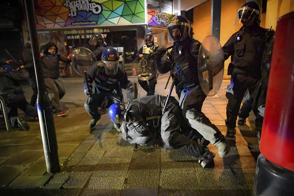 Police officers detain a man during the 'Kill The Bill' protest, in Bristol, Friday, March 26, 2021. Police in Bristol have arrested 10 people during a third night of protest against a new policing law. Hundreds of demonstrators against the Police, Crime, Sentencing and Courts Bill staged a sit-down protest outside a police station in the southwest England city on Friday night. The Avon and Somerset Police force said Saturday that eggs, bottles and bricks were thrown at officers and a police horse was daubed with paint. (Ben Birchall/PA via AP)