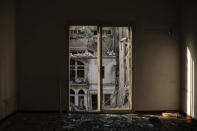 A destroyed building is seen through the window of a bedroom heavily damaged in last week's explosion that hit the seaport of Beirut, Lebanon, Tuesday, Aug. 11, 2020. Beirut's massive explosion is just the latest in multiple crises that have hit Lebanon the past year, including massive protests, economic collapse and the coronavirus pandemic. Some Lebanese, whether poor or middle class, now feel their resolve is simply broken. (AP Photo/Felipe Dana)
