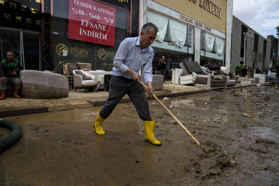 A man cleans a street on the aftermath of floods caused by heavy rains in Istanbul, Turkey, Wednesday, Sept. 6, 2023. Severe rainstorms that lashed parts of Greece, Turkey and Bulgaria have caused several deaths as rescuers continue searching for missing people. (AP Photo/Khalil Hamra)