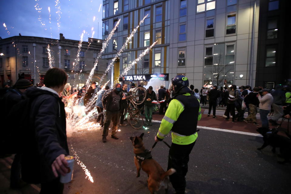 Fireworks are launched as police officers with dogs arrive to a protest against a new proposed policing bill, in Bristol, Britain, March 21, 2021. REUTERS/Peter Cziborra