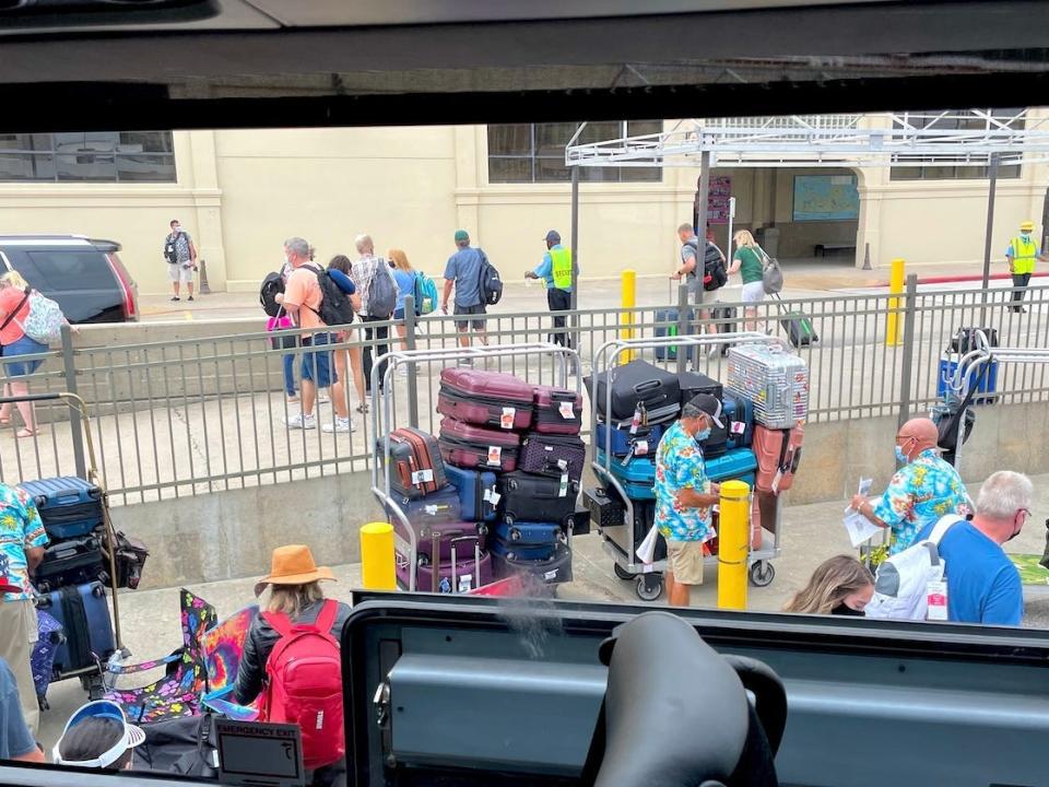 An image of crew members grabbing luggage.