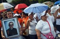 Catholics brave the rain for a mass celebrating the beatification of Salvadorean archbishop Oscar Romero at the Salvador del Mundo square in San Salvador on May 23, 2015