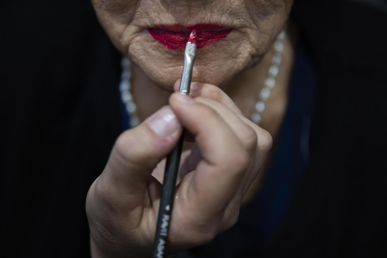 Holocaust survivor Rivka Papo, 87, gets make-up applied during a special beauty pageant honoring Holocaust survivors in Jerusalem, Tuesday, Nov. 16, 2021. Ten contestants participated in the "Miss Holocaust Survivor" pageant, which was held for the first time since 2019 after being suspended due to the coronavirus pandemic. (AP Photo/Oded Balilty)