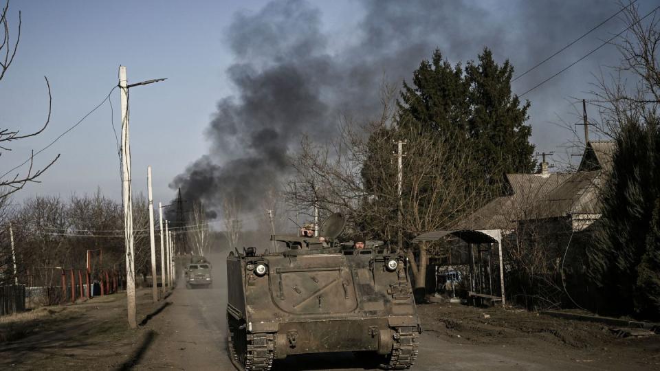 Ukrainian servicemen drive an M113 armored personnel carrier in the town of Chasiv Yar as smoke rises from the direction of Bakhmut on March 20, 2023. (Aris Messinis/AFP via Getty Images)