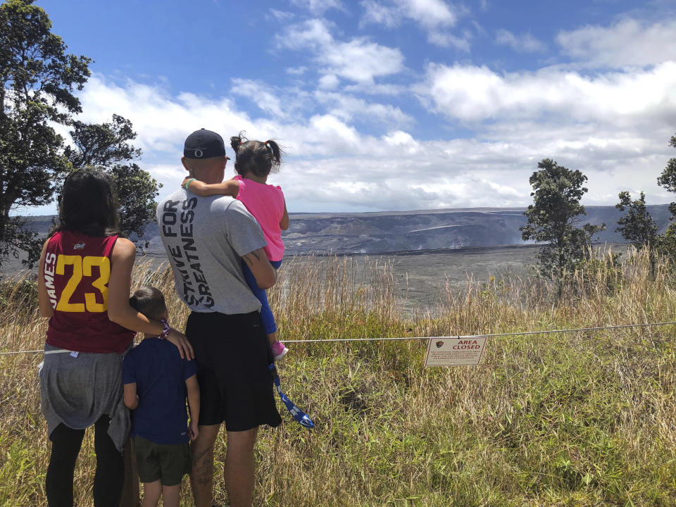 In this Saturday, Sept. 22, 2018, photo released by the National Park Service tourists visit Hawaii Volcanoes National Park on the first day the park reopened after volcanic activity forced the park to close for more than four months in Hawaii. (Janice Wei/National Park Service via AP)