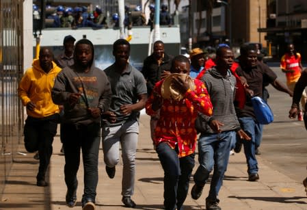 Protesters flee from teargas during clashes after police banned planned protests over austerity and rising living costs called by the opposition Movement for Democratic Change (MDC) party in Harare