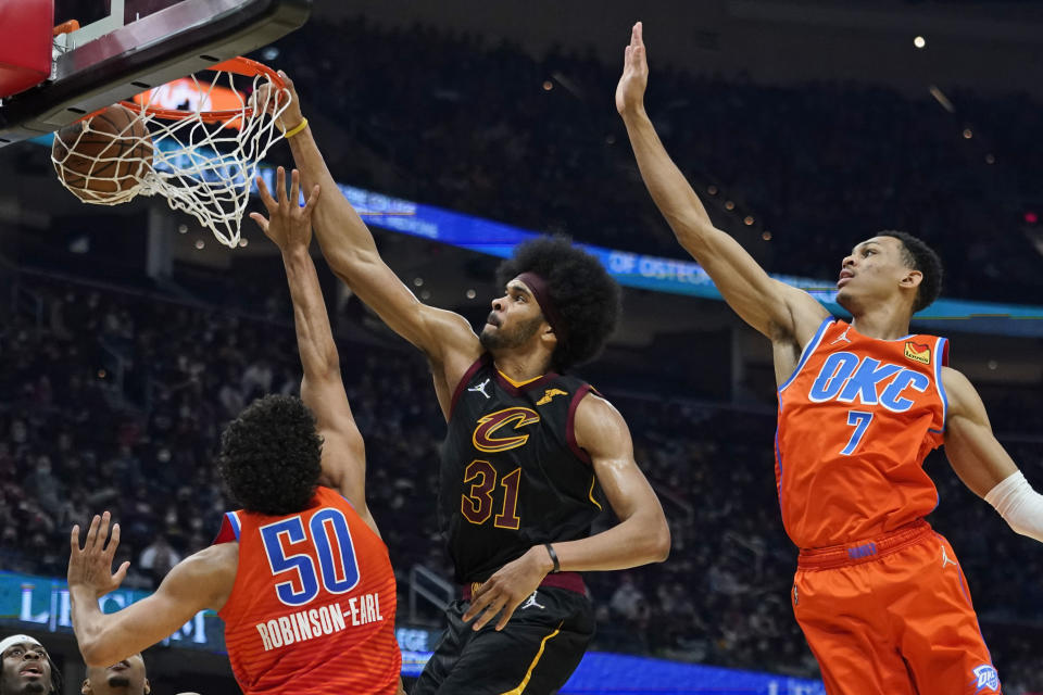 Cleveland Cavaliers' Jarrett Allen (31) dunks the ball against Oklahoma City Thunder's Jeremiah Robinson-Earl (50) Darius Bazley (7) and in the first half of an NBA basketball game, Saturday, Jan. 22, 2022, in Cleveland. (AP Photo/Tony Dejak)