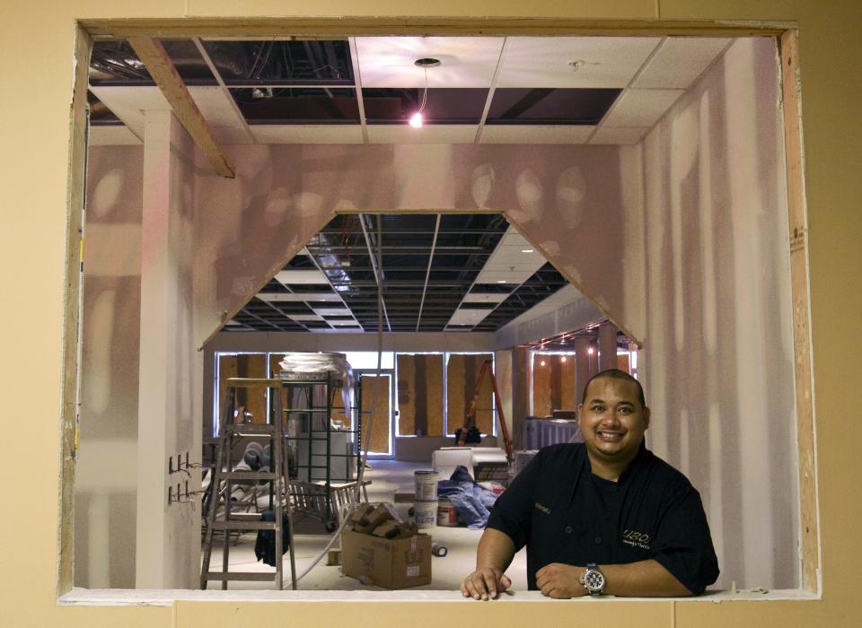 In this Aug. 13, 2011 photo, Norrawit Milburn, owner and executive chef of the soon-to-open Ubon Thai cuisine restaurant in the Shipyard Shops at the Wilmington Riverfront stands in the passthrough that will let customers see into the kitchen. The restaurant is named for Milburn's family hometown in Thailand.