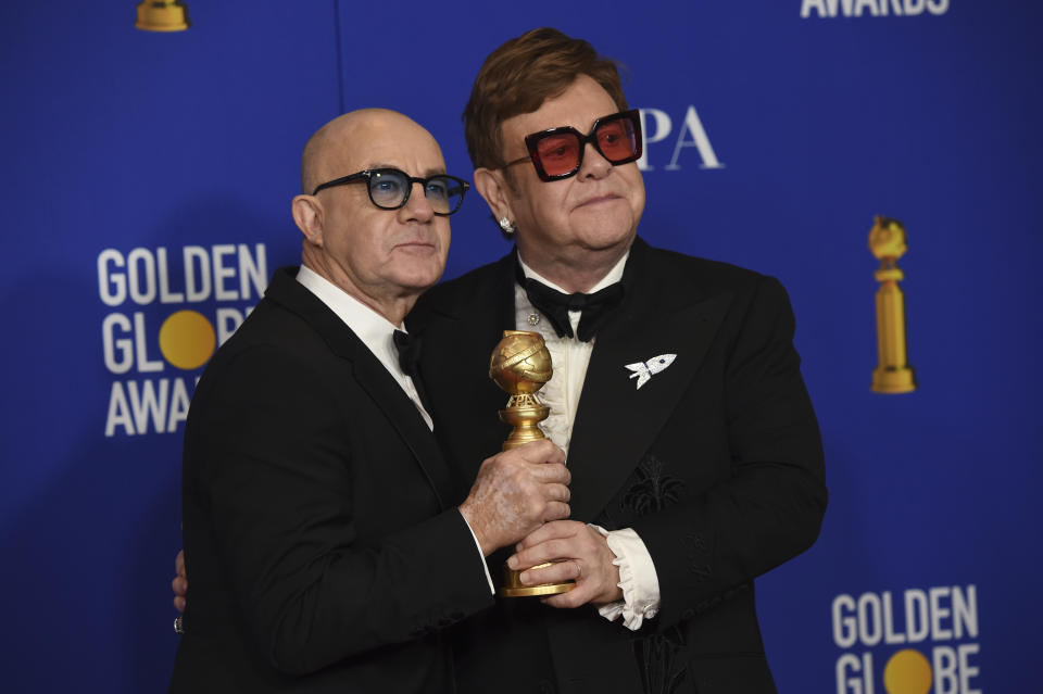 Elton John, right, and Bernie Taupin pose in the press room with the award for best original score in a motion picture for "I'm Gonna Love Me Again" from "Rocketman" at the 77th annual Golden Globe Awards at the Beverly Hilton Hotel on Sunday, Jan. 5, 2020, in Beverly Hills, Calif. (AP Photo/Chris Pizzello)