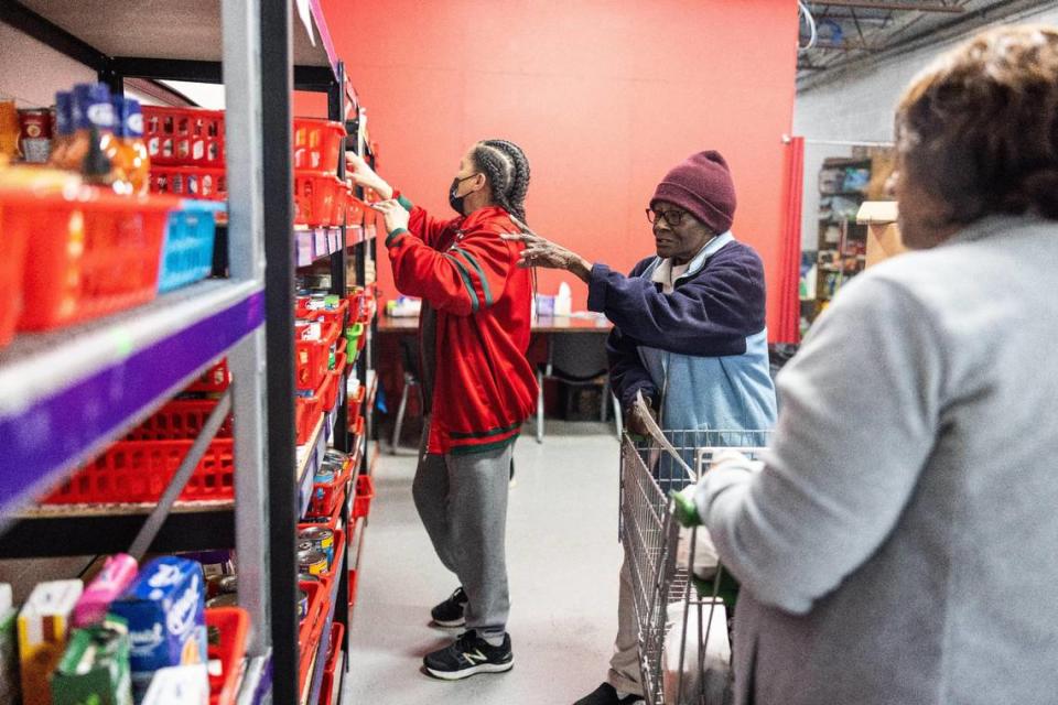 Volunteer Shirley Collins, center, helps a client pick out groceries at Nourish Up’s Mt. Carmel food pantry in Charlotte. Khadejeh Nikouyeh/Knikouyeh@charlotteobserver.com