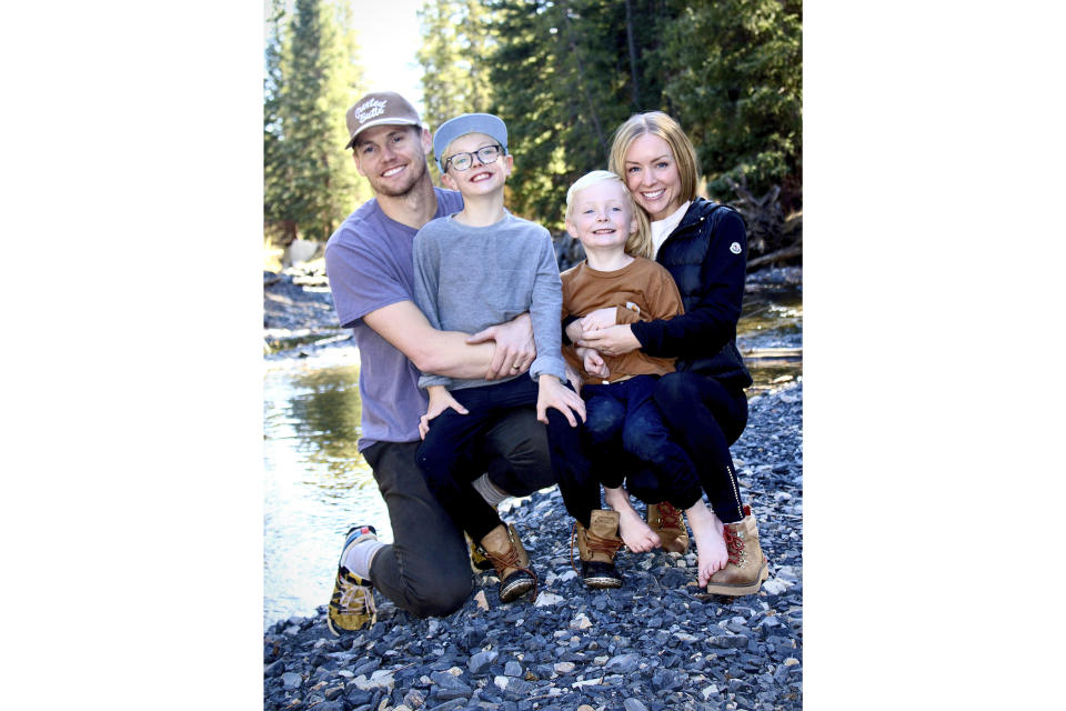 This undated photo released by Cameron Clifford, shows the Clifford family, from left to right; Cameron, Cal, Lyle and Kari who own Terrance, the pet octopus his son Cal adopted at their home in Edmond, Okla. The family soon learned that Terrance was female as she laid 50 eggs that later hatched, with nearly half of them surviving. Although female octopuses usually die soon after laying their eggs, Terrance is still alive four months later. (Cameron Clifford via AP)