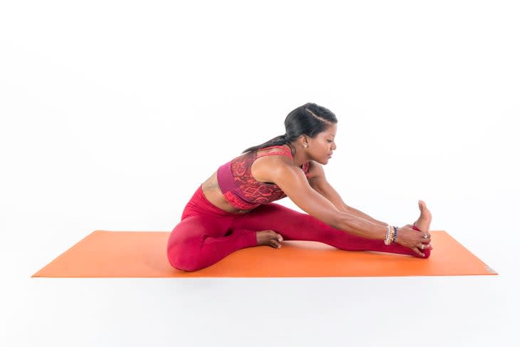 A person demonstrates Head-to-Knee Pose (Janu Sirsasana) in yoga