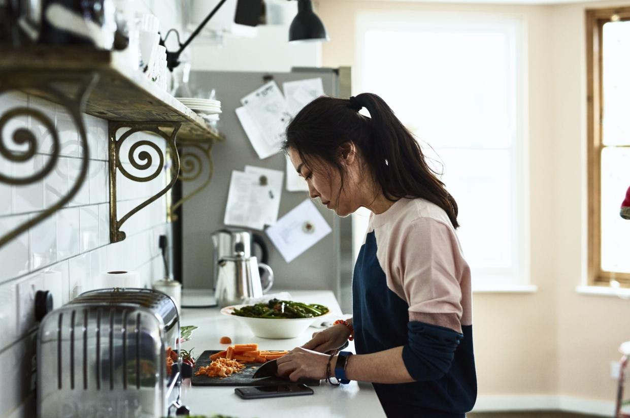 woman chopping vegetables on kitchen counter