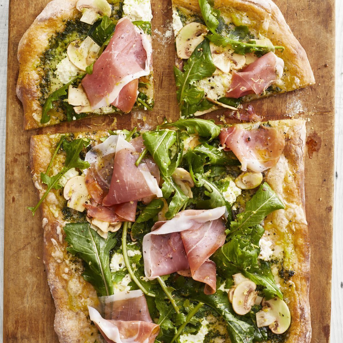 spring dinner ideas pesto pizza with arugula and prosciutto