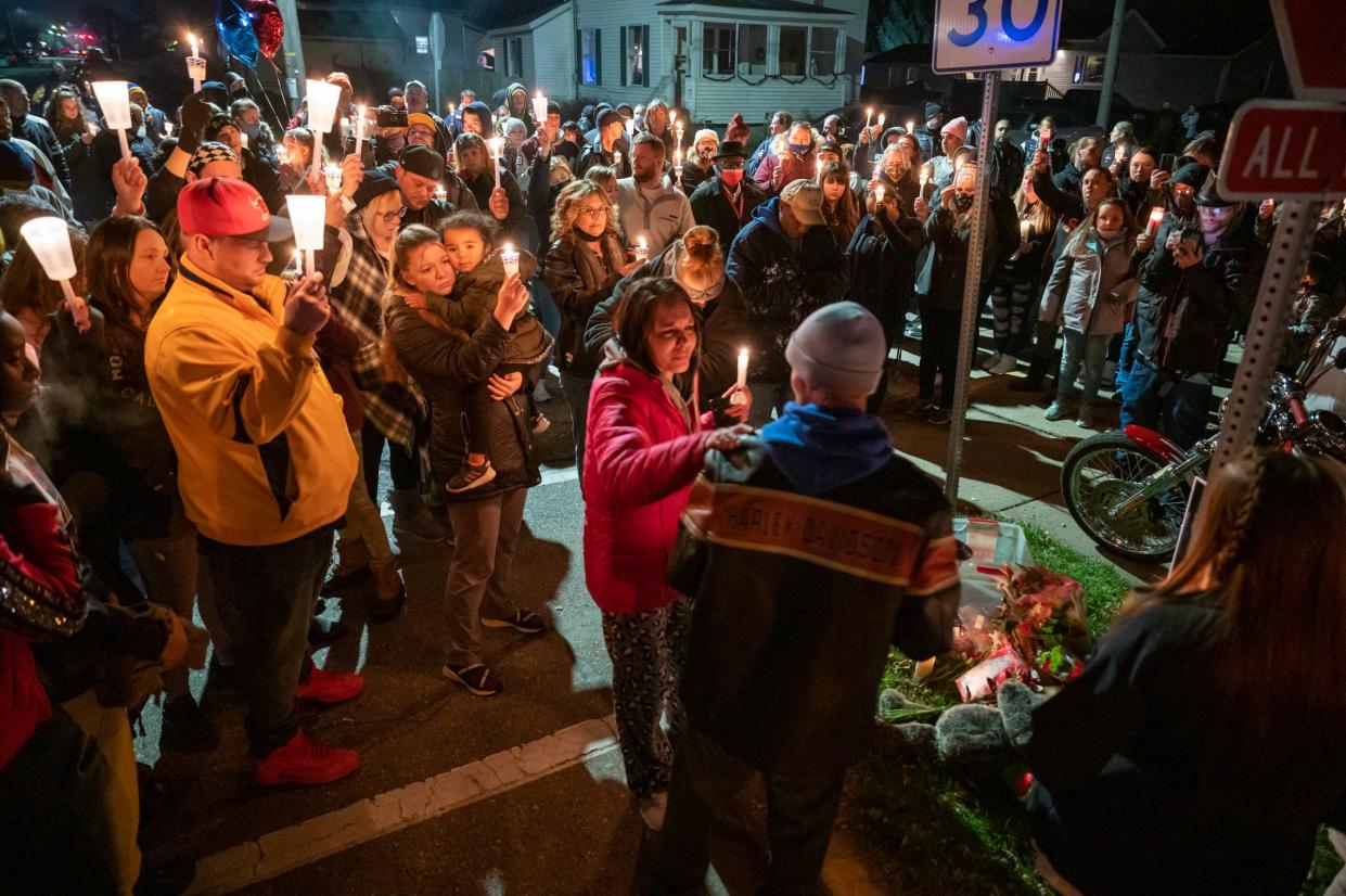 People gather around a memorial Dec. 9, 2020, at 13th and Spring streets in Mishawaka where Clayton McClish and his girlfriend, Elizabeth Johnson-Neher were killed Wednesday Dec. 2, 2020, when a vehicle being pursued by Mishawaka police crashed into McClish’s car. SOUTH BEND TRIBUNE, MATT CASHORE